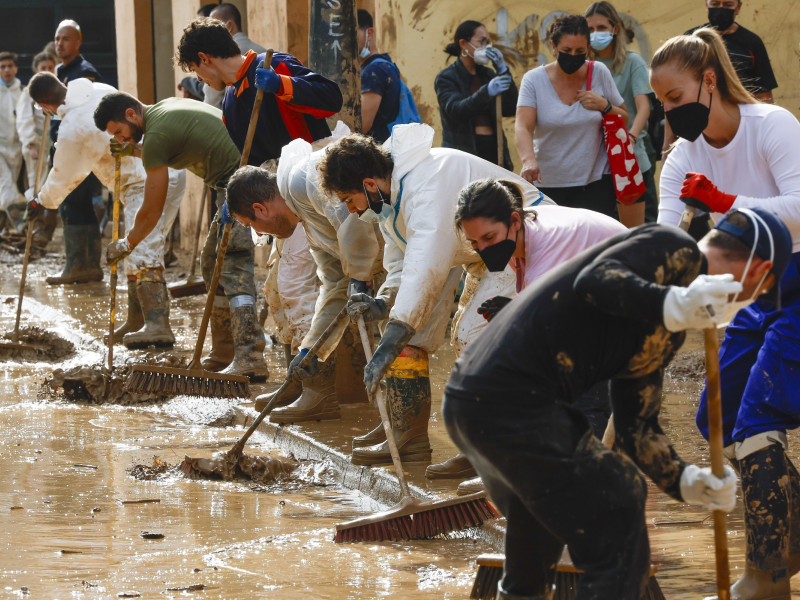 Voluntarios limpian una calle de Alfafar