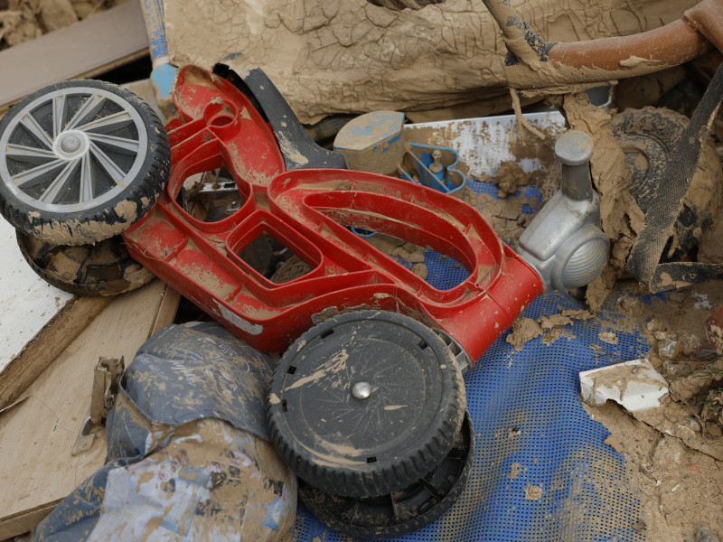 Juguetes infantiles aparecen entre los escombros acumulados en las calles de Alfafar