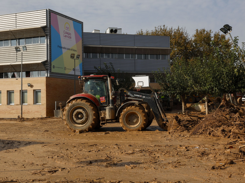 Una excavadora retira el lodo del colegio Larrodé en Catarroja, Valencia