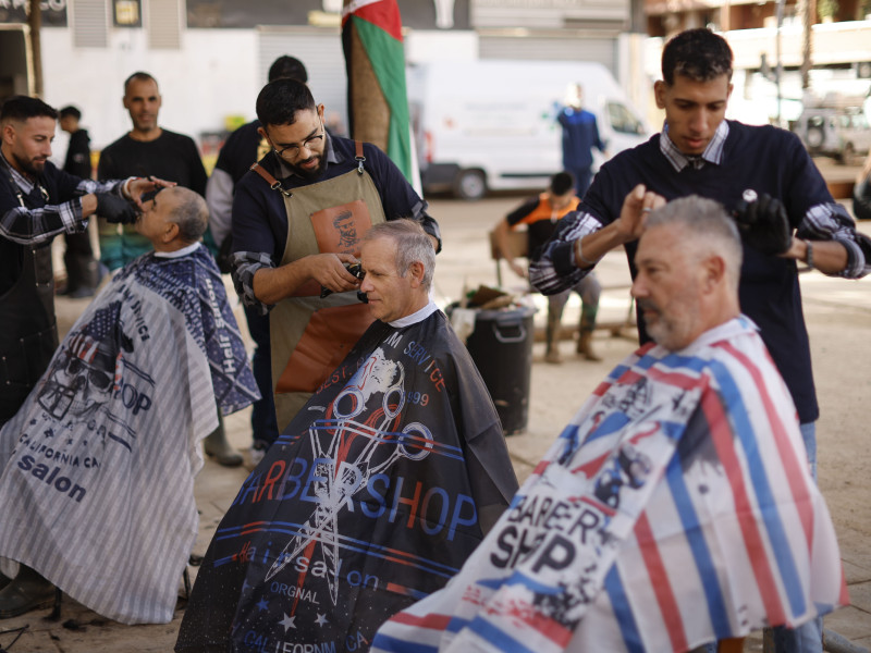 Peluqueros voluntarios de Murcia trabajan en la calle en Catarroja, este martes