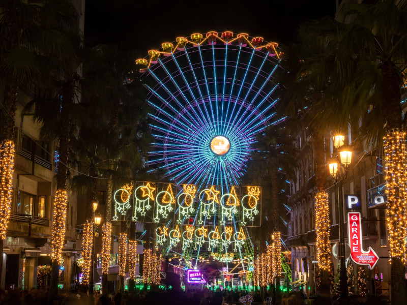 Luces navideñas en la calle Colón en el centro de la ciudad de Vigo en España con la gran noria navideña