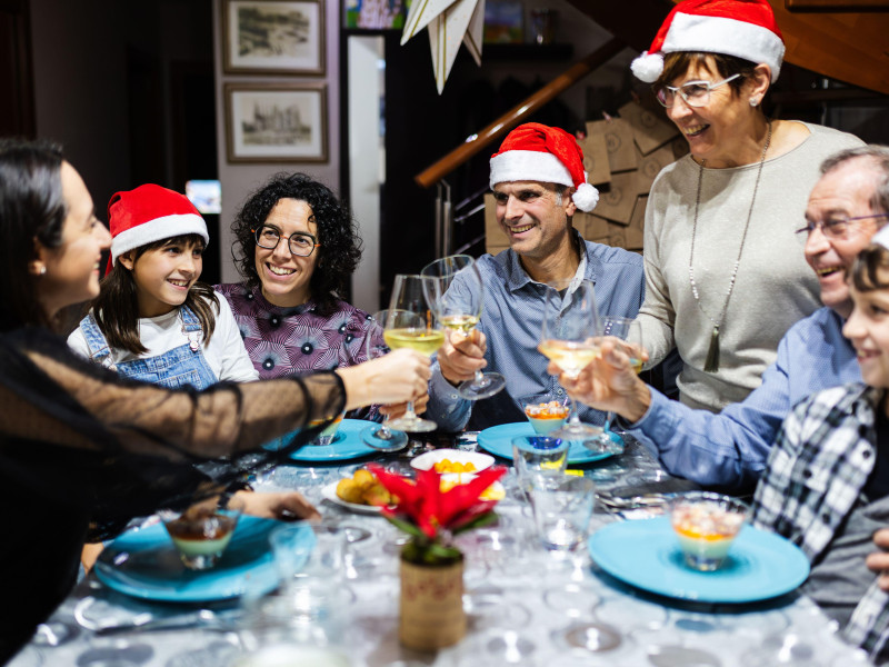 Gran familia española feliz disfrutando de la celebración de la cena navideña en casa