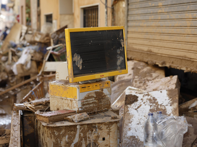 Restos tecnológicos llenos de barro en una calle de la localidad valenciana de Paiporta