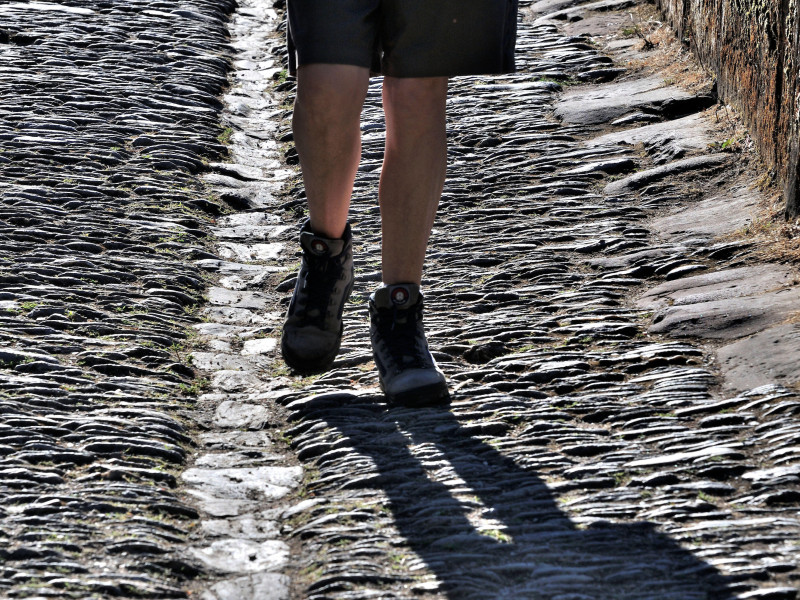 Excursionista llegando a Conques, en el departamento de Aveyron, en el Camino de Santiago, Voie du Puy, Francia.