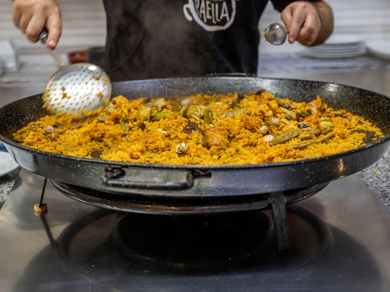 Cocinero preparando una paella valenciana, Valencia, España