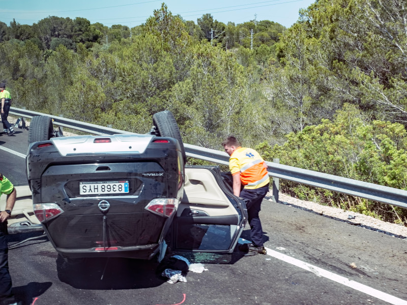 Accidente en la carretera con un policía y un médico buscando víctimas