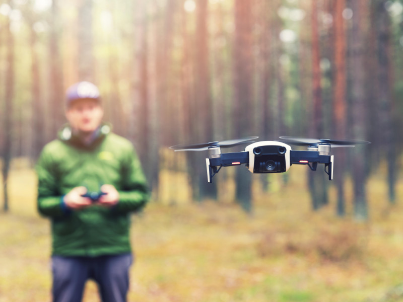 Hombre volando un dron en el bosque