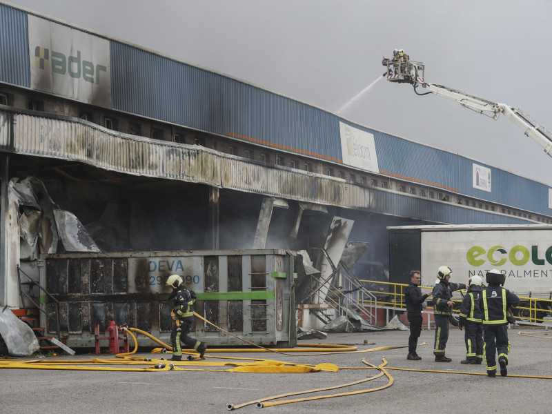 Los bomberos trabajando junto a una nave incendiada