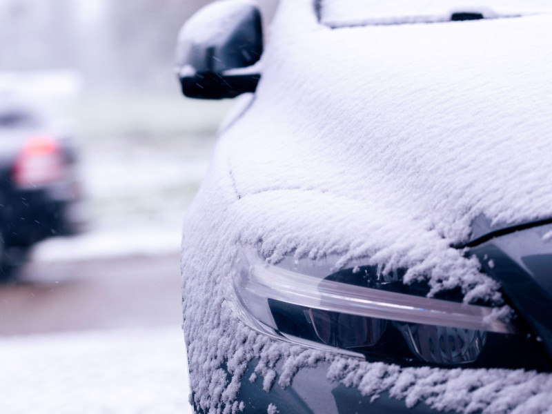 El costado de un automóvil que comienza a quedar cubierto por la nieve durante una tormenta de nieve