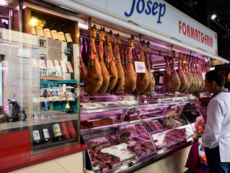 Carnicería con jamones ibéricos típicos en un gran mercado del centro de Barcelona. España