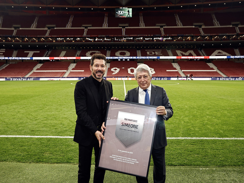 El entrenador del Atlético de Madrid, Diego Simeone, recibe de manos del presidente del Club, Enrique Cerezo, una placa conmemorativa por sus 700 encuentros oficiales al frente del equipo