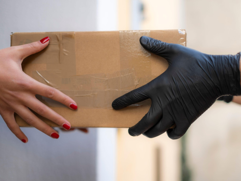 Mujer recibe en casa paquete de envío de repartidores, compra de comercio electrónico