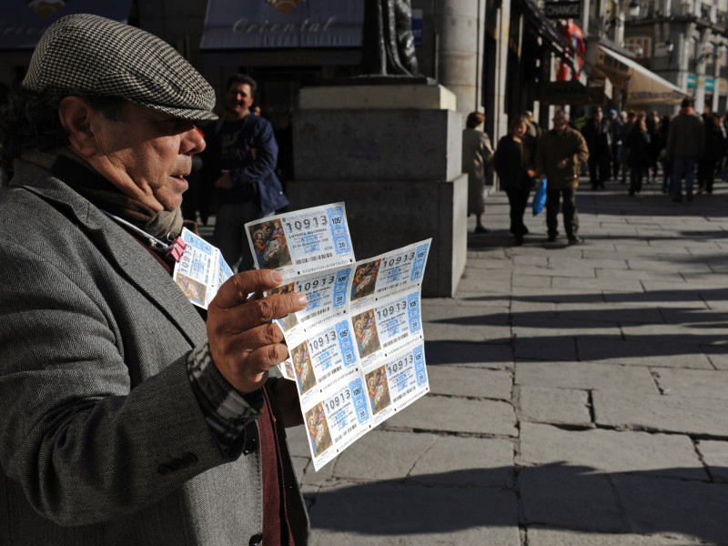 Un hombre vende un billete de lotería nacional de Navidad de El Gordo en la Puerta del Sol de Madrid España