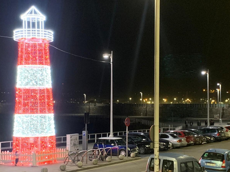 Faro iluminado en el Muelle del Puerto Deportivo de Gijón, durante la Navidad de 2024