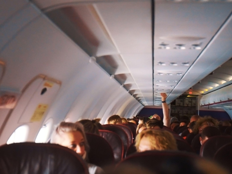 Interior de un gran avión moderno con pasajeros sentados en los asientos. La fotografía está tomada desde el interior del avión en España. Vista interior de un avión