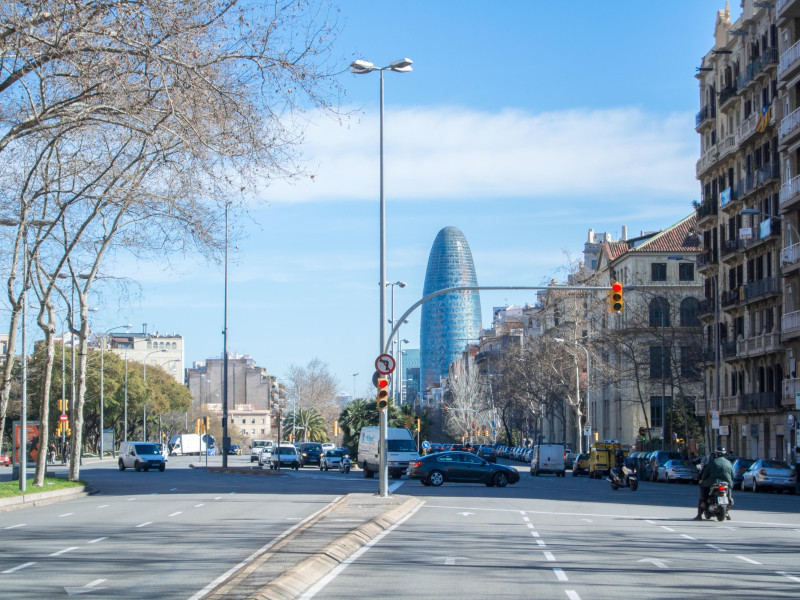 Vista de una calle de Barcelona con coches, gente y edificios modernos, Cataluña