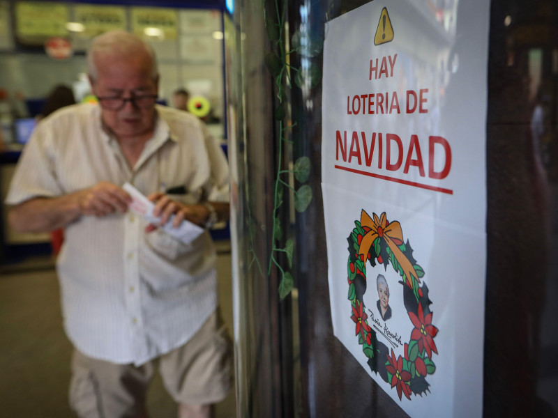 Un hombre sale después de comprar un boleto de lotería de Navidad en la sucursal de lotería.