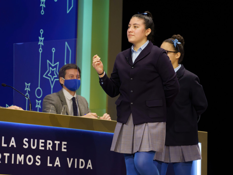 Yanisse Alexandra, una de las niñas de la residencia San Ildefonso, posa minutos después de cantar el primer premio 86.148, durante la celebración del Sorteo Extraordinario de Lotería de Navidad 2021 en el Teatro Real de Madrid