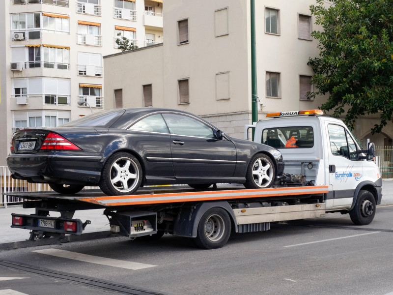 Coche de lujo en grúa de plataforma plana, España