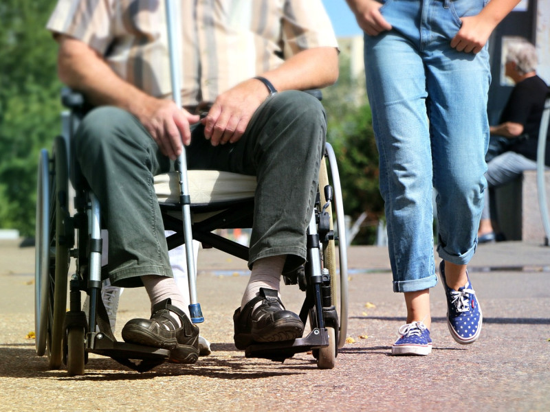 Voluntario ayudando a una persona con movilidad reducida