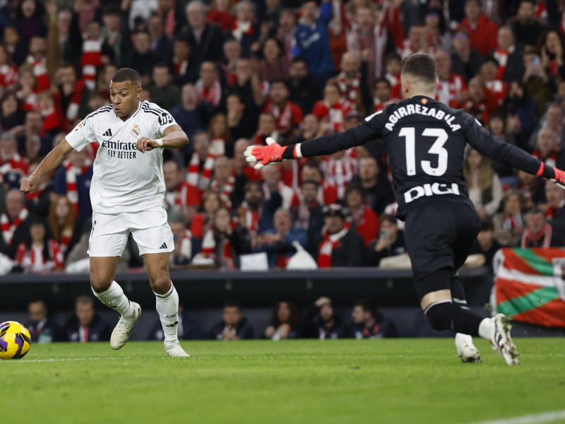 El delantero del Real Madrid Kyllian Mbappé (i) se dispone a chutar ante el portero Julen Agirrezabala, del Athletic, durante el partido de LaLiga que Athletic Club y Real Madrid disputan este miércoles en el estadio de San Mamés, en Bilbao