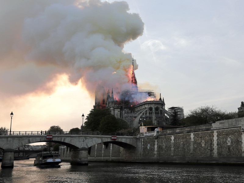 Fotografía de archivo que muestra la aguja de la Catedral de Notre Dame en llamas durante el incendio que el 15 de abril de 2019 calcinó uno de los edificios más conocidos de París