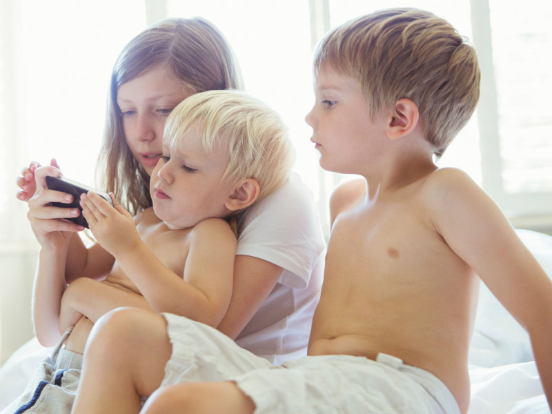 Niños usando el teléfono celular juntos