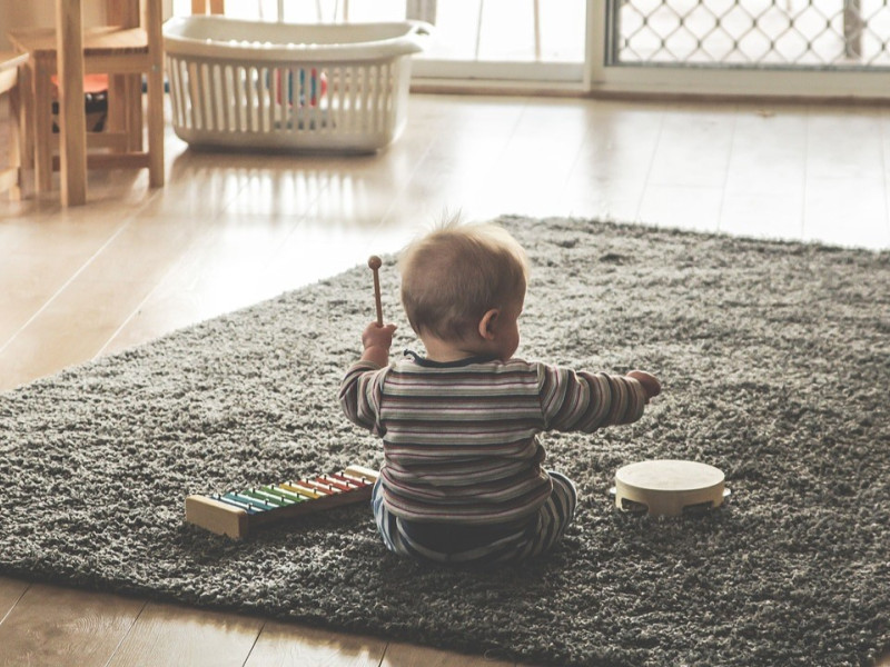 Niño jugando con un xilófono y una pandereta