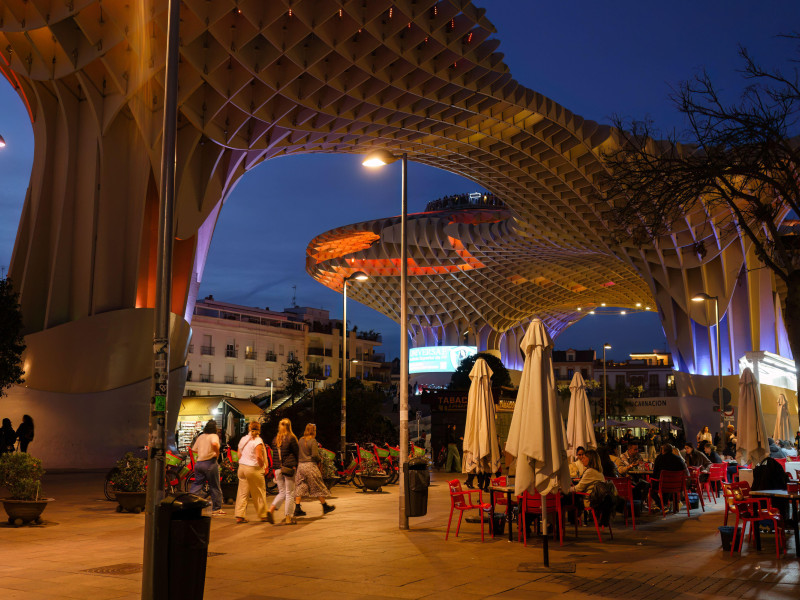 Gente disfrutando de una velada en la plaza y restaurante bajo las Setas de Sevilla