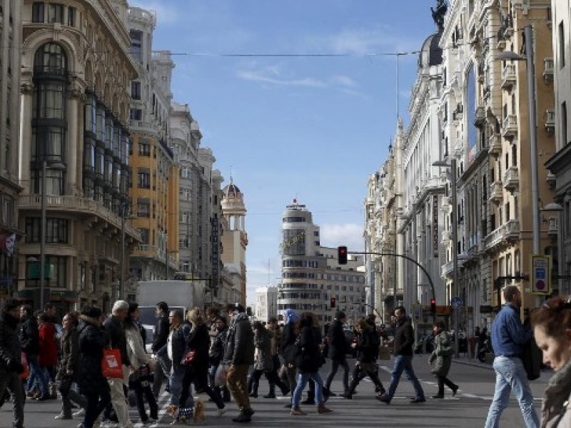 Personas cruzando por un paso de peatones en plena Gran Vía durante estas Navidades