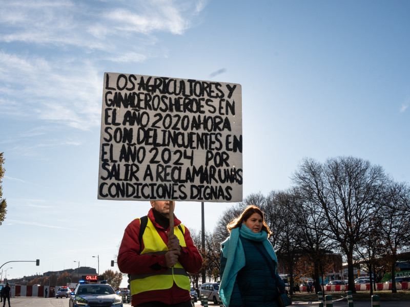 Un agricultor con un cartel durante una protesta de agricultores y ganaderos frente al Ministerio de Agricultura