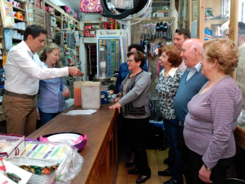 Los dependientes de la tienda atendiendo a vecinos de la localidad