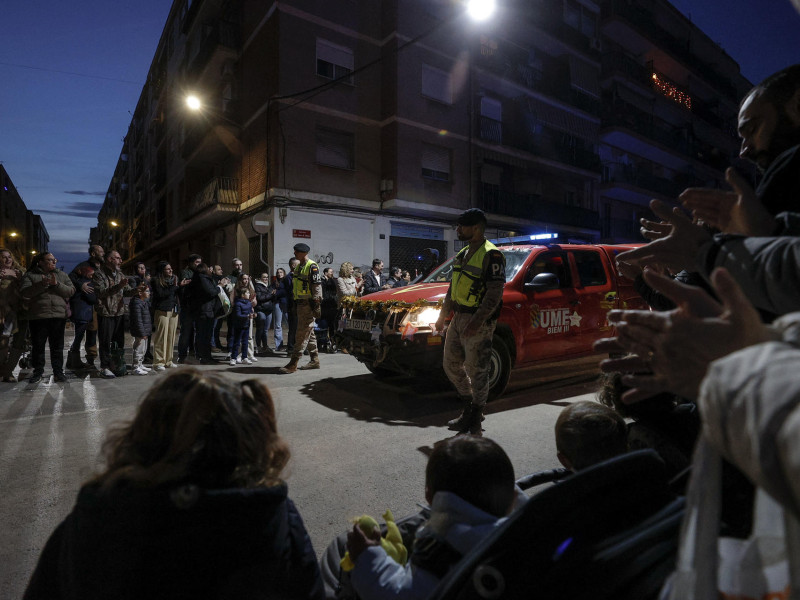 GRAFCVA4568. PAIPORTA (VALENCIA), 05/01/2025.- Los Reyes Magos han protagonizado este domingo por la tarde las cabalgatas que recorrido las calles de numerosas localidades de la Comunitat Valenciana, las más emotivas han sido las que han recorrido las localidades afectadas por las riadas. En la imagen miembros de la UME participan en la cabalgata recibiendo el aplauso de los vecinos de Paiporta. EFE/Manuel Bruque