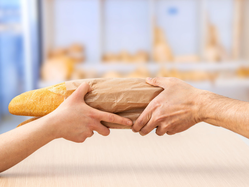 Fotografía recortada de una mujer comprando pan fresco en una cafetería