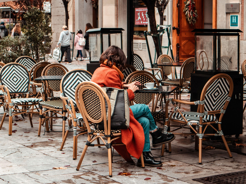 Una acogedora terraza de cafetería o restaurante con mesas y sillas en un día de otoño.