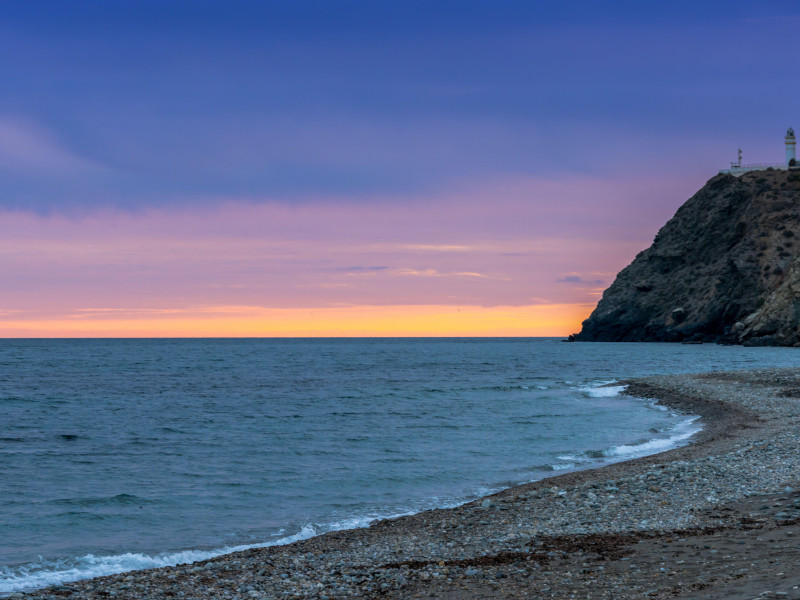 Vista de la playa de La Chucha y el faro de Cabo Sacratif en Andalucía al atardecer