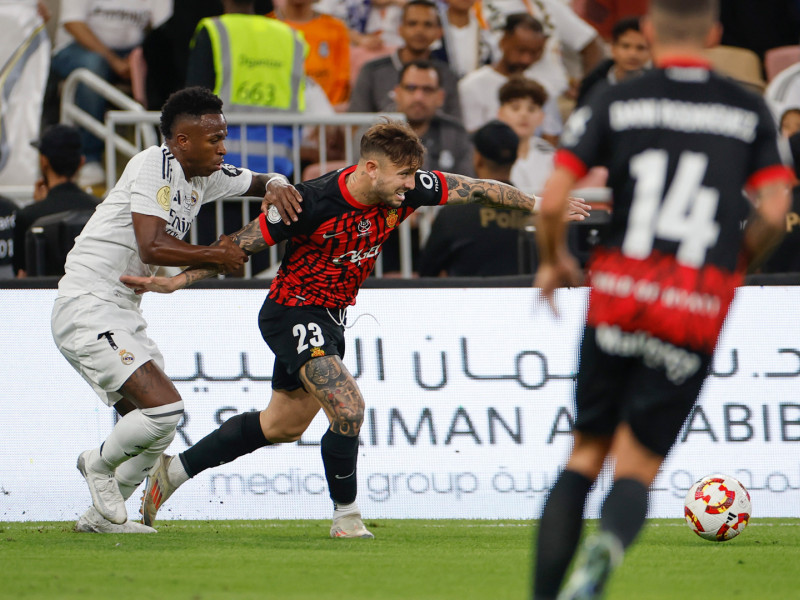 Vinicius agarra a Maffeo para evitar el avance del lateral del Mallorca en el partido de Supercopa de España frente al Real Madrid