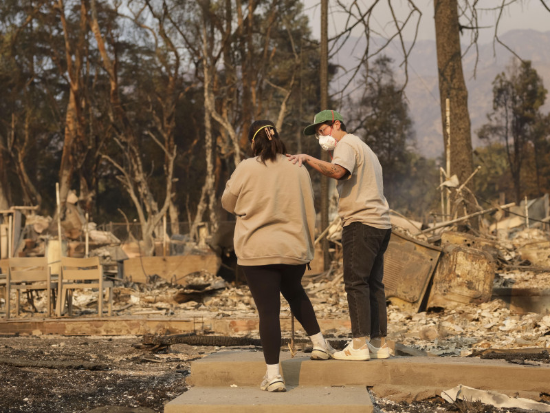 Personas observan los restos de una casa destruida por el incendio forestal de Eaton en Altadena, California, EE. UU., el 9 de enero de 2025