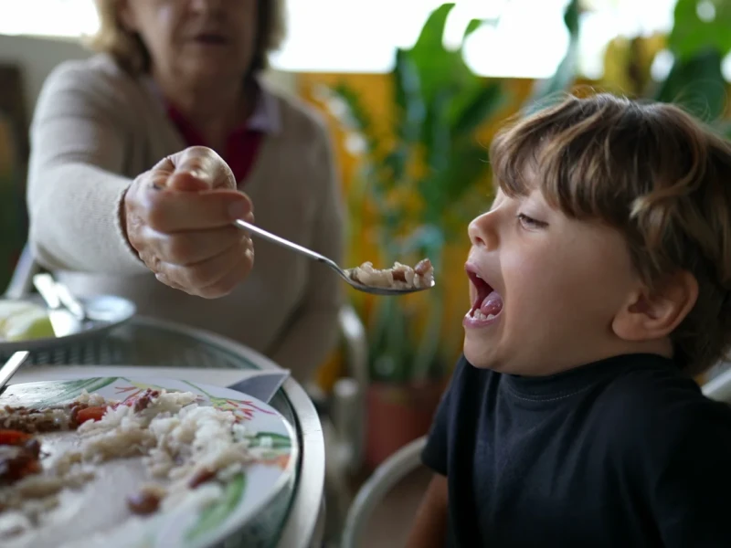 Una abuela dando de comer a su nieto