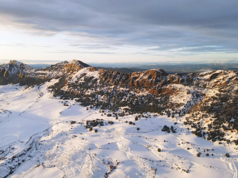 Vista aérea de montañas cubiertas de nieve al atardecer en la sierra de Obarenes, provincia de Burgos