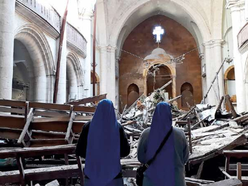 Religiosas cristianas en una iglesia destruida en Alepo