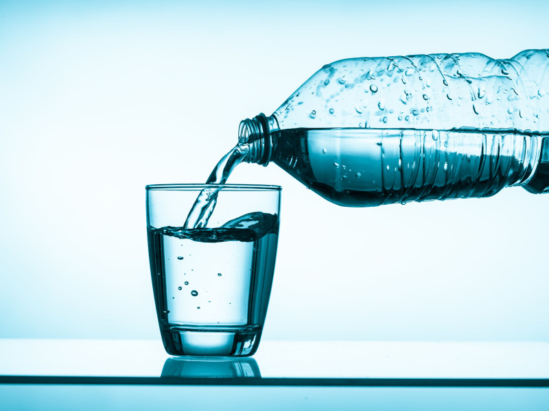 Agua vertida de una botella a un vaso