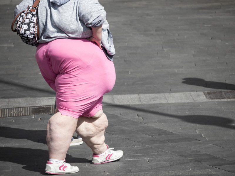 Mujer joven obesa caminando por el centro de la ciudad