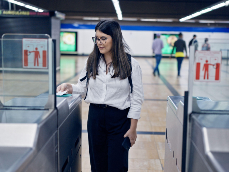 Chica joven pasando la tarjeta de trasporte para entrar al Metro de Madrid