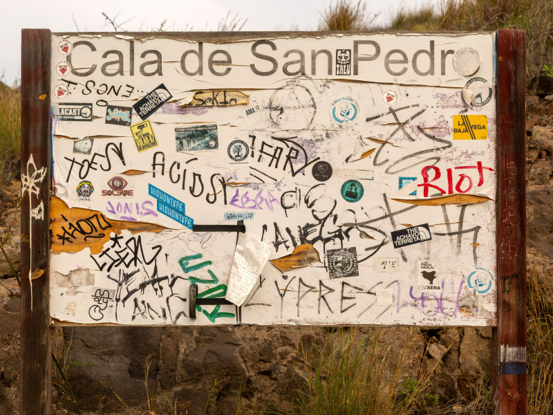 Graffiti hippie pintado en tablón de anuncios, pueblo abandonado de Cala de San Pedro, Parque Natural Cabo de Gata, Nijar, Almería