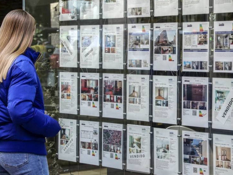 Una mujer mirando ofertas de pisos en una inmobiliaria