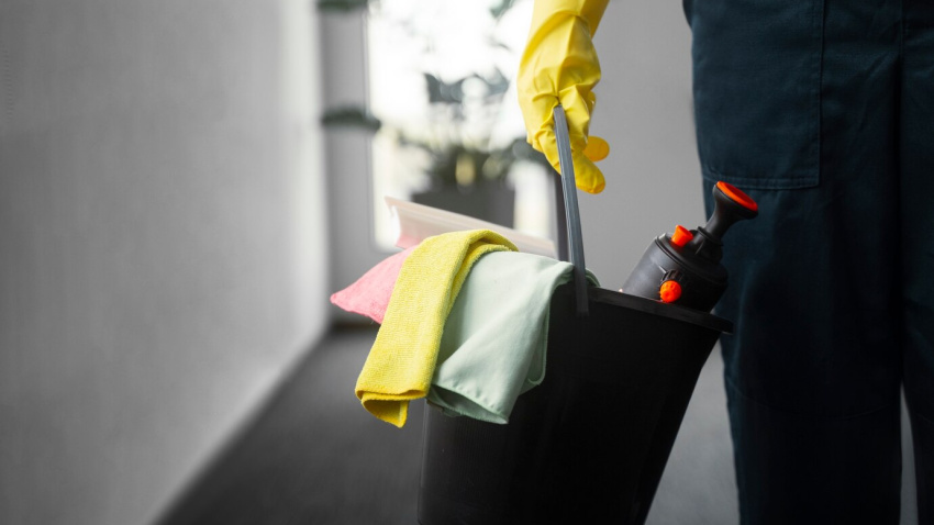 Una mujer con útiles de la limpieza