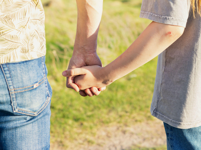 Un hombre pasea mientras sostiene la mano de su hija