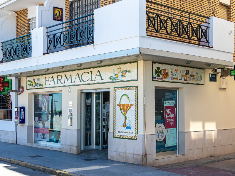 Farmacia española abierta. Tienda farmacéutica con cruz verde iluminada.