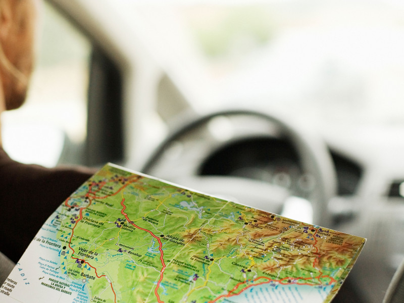 Hombre en un coche mirando un mapa de España